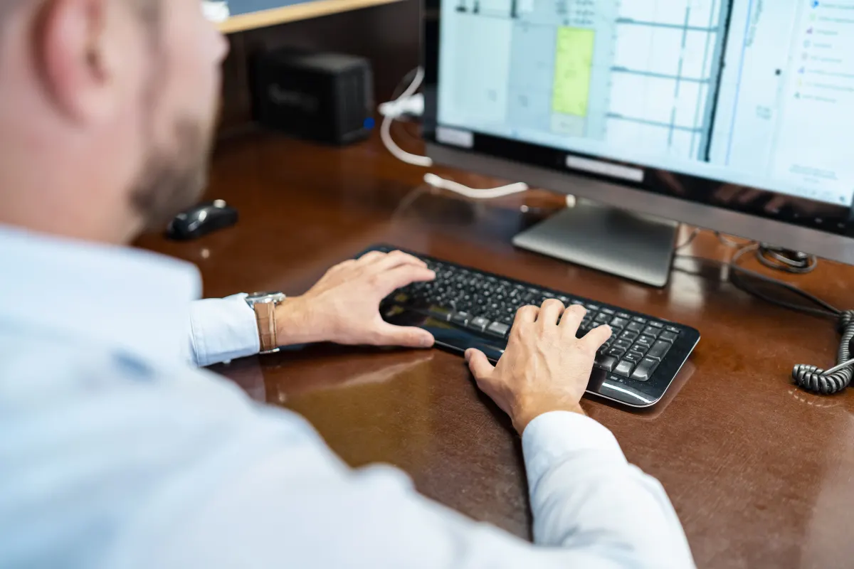 Close-up-of-businessman-working-on-desktop-pc-in-o-2024-09-22-13-46-34-utc