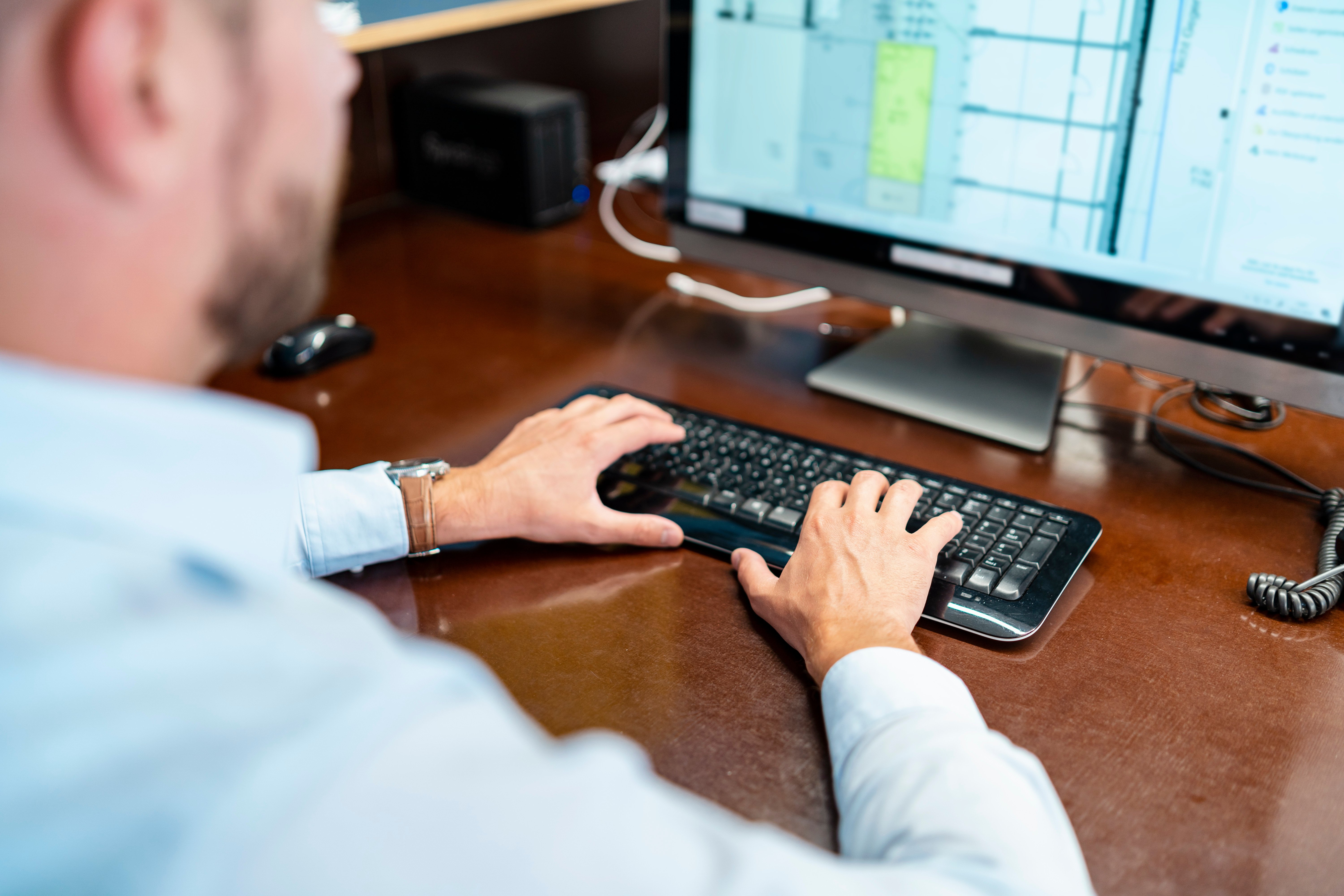close-up-of-businessman-working-on-desktop-pc-in-o-2024-09-22-13-46-34-utc