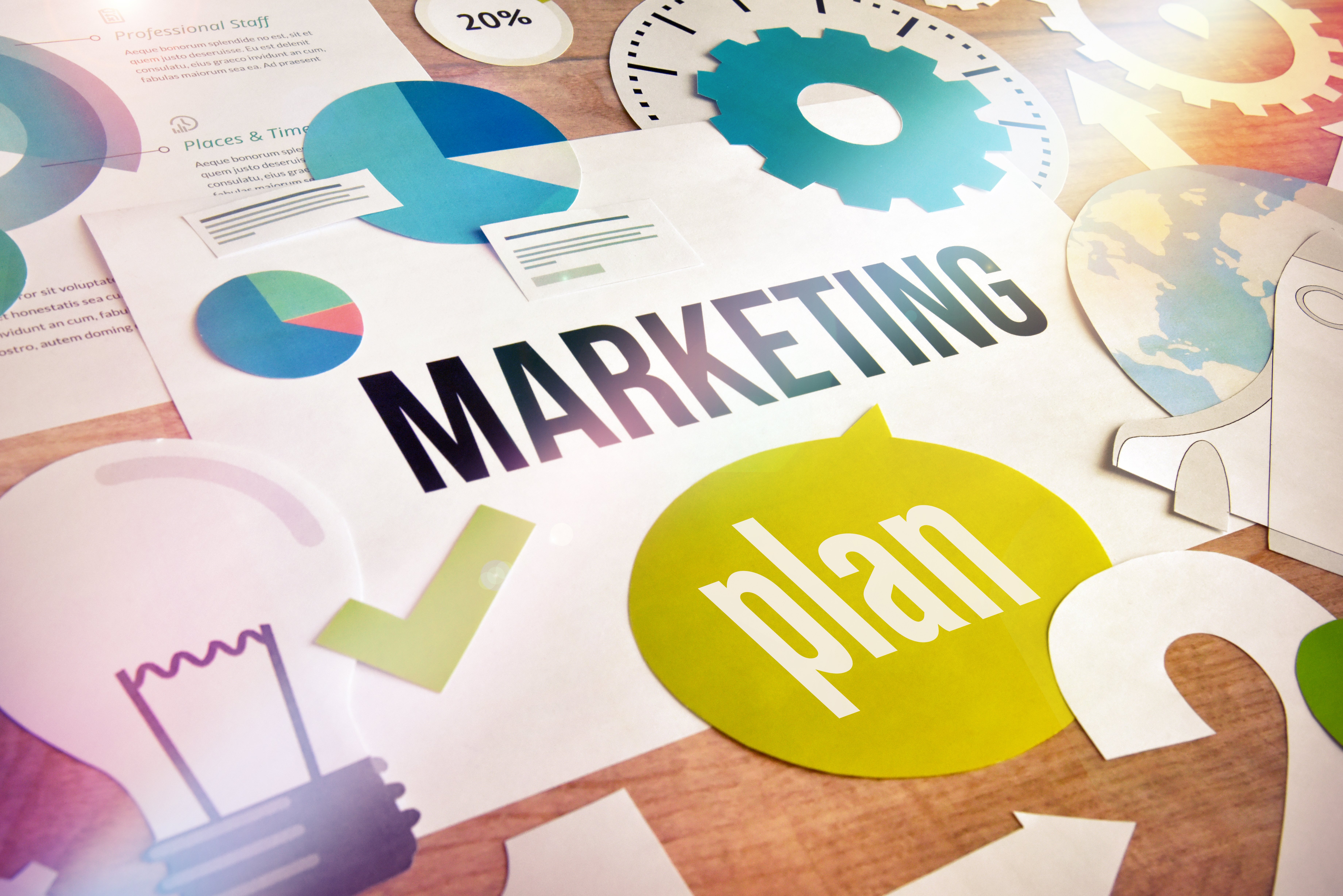marketing plan written on a piece of paper surrounded by different charts. 
